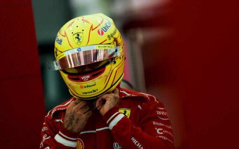 a man wearing a yellow helmet and holding his hand to his face