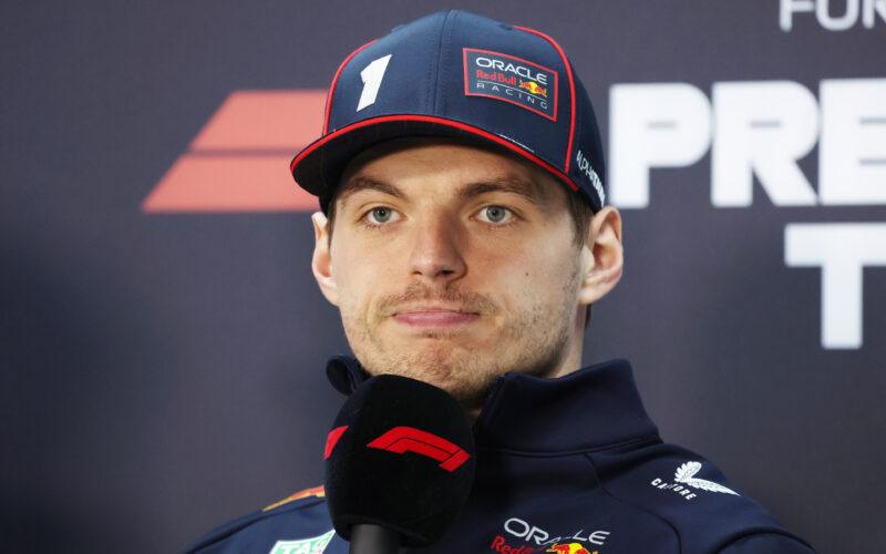 a man with a cap on and microphone in front of him