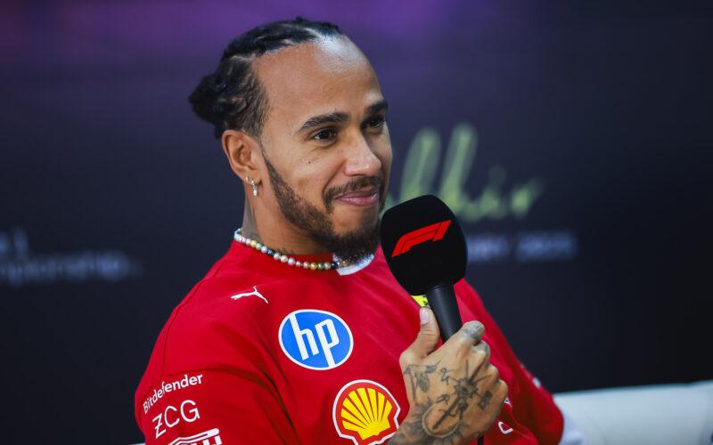 a man in a red shirt holding a microphone