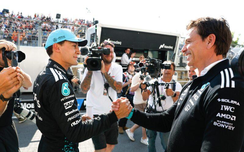 two men shaking hands in front of a crowd